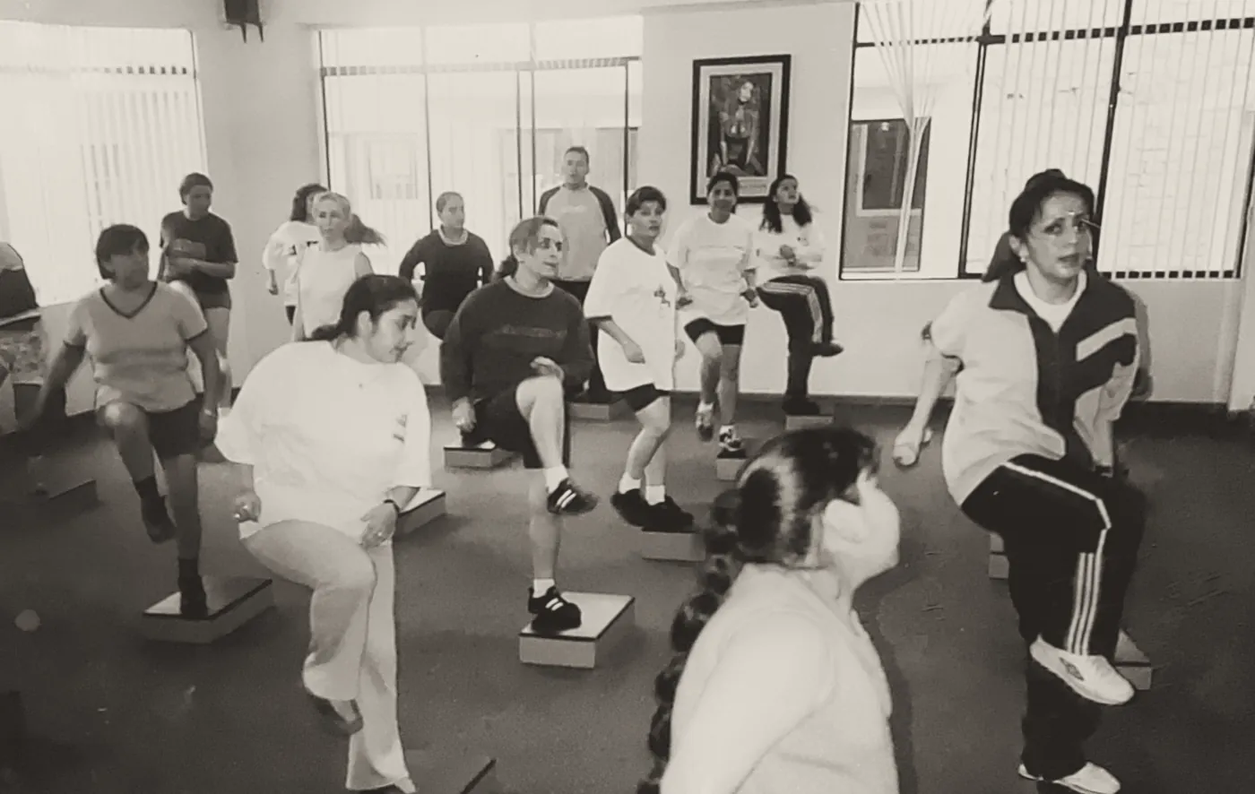 Una clase de step en una foto antigua del gimnasio.