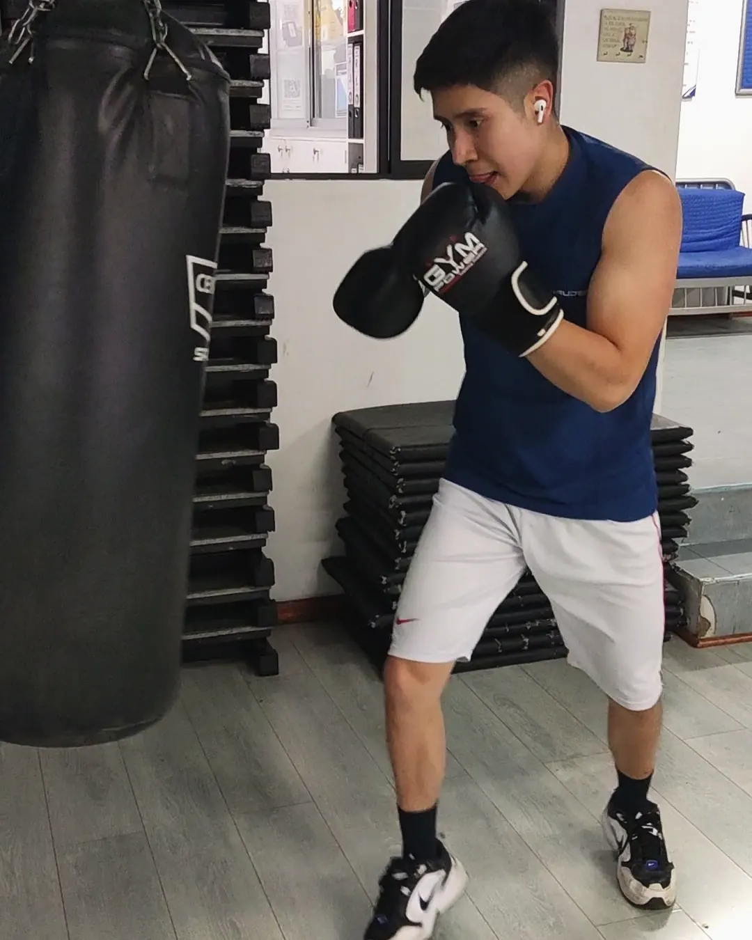 Un socio golpea el saco con guantes de box en el área funcional.